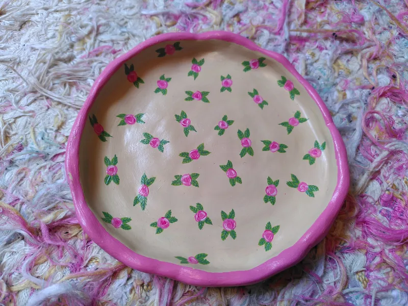 image de la coupelle ronde à liseré rose avec des petites roses et leurs petites feuilles peintes à l'intérieur
